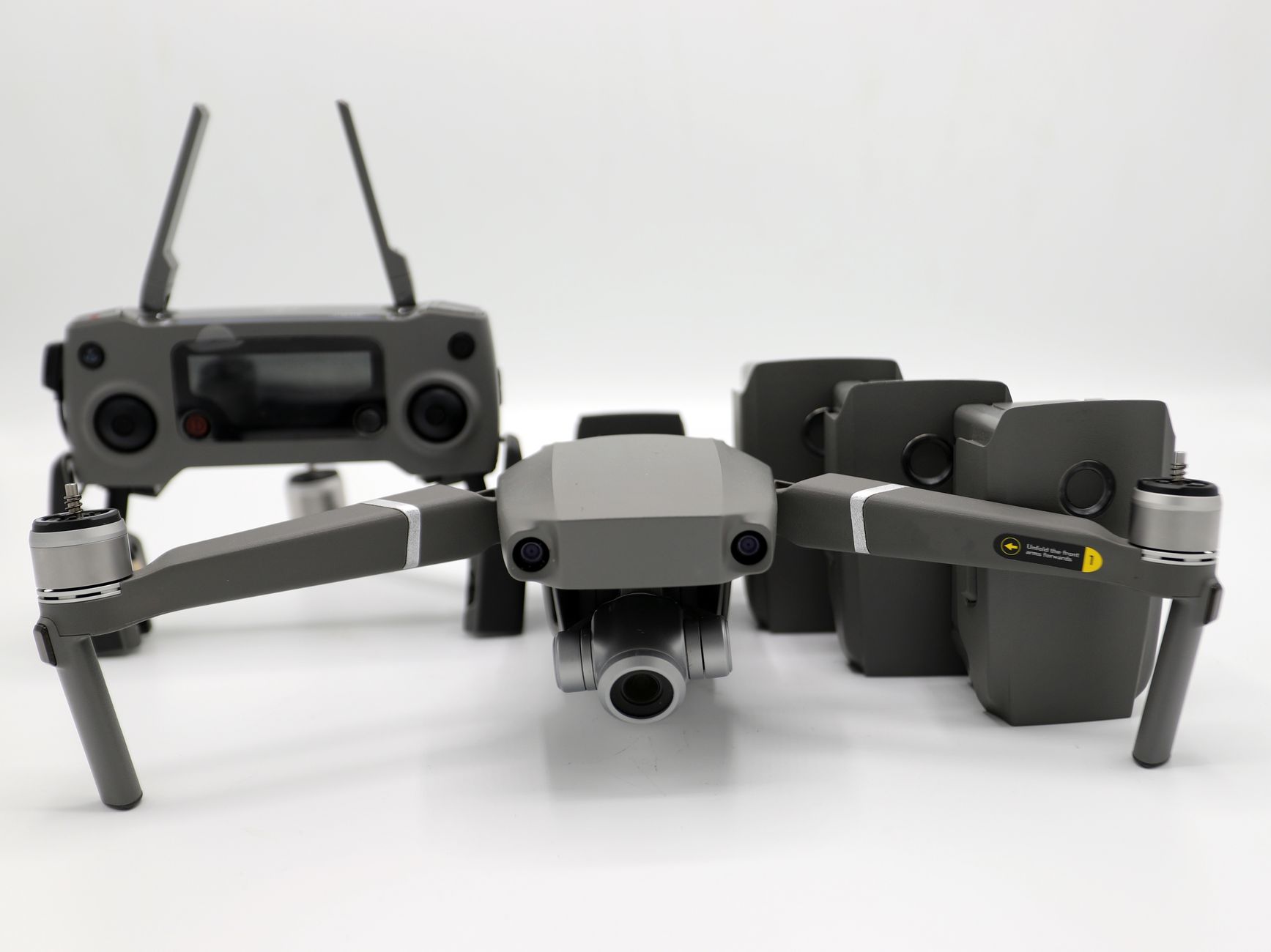 Modern drone and remote on white backdrop, showcasing advanced technology.